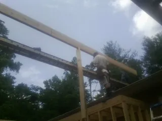 Carpenter setting a ridge beam over a new addition frame — Ice Dam Removal by Roofing Brothers in Pico Rivera