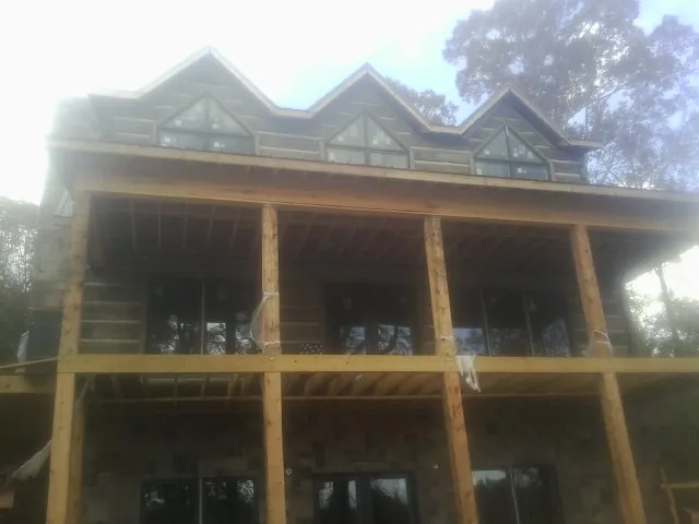 Dormers and porch framing on a large log home under construction — Roof Coating work by our crew in Pico Rivera