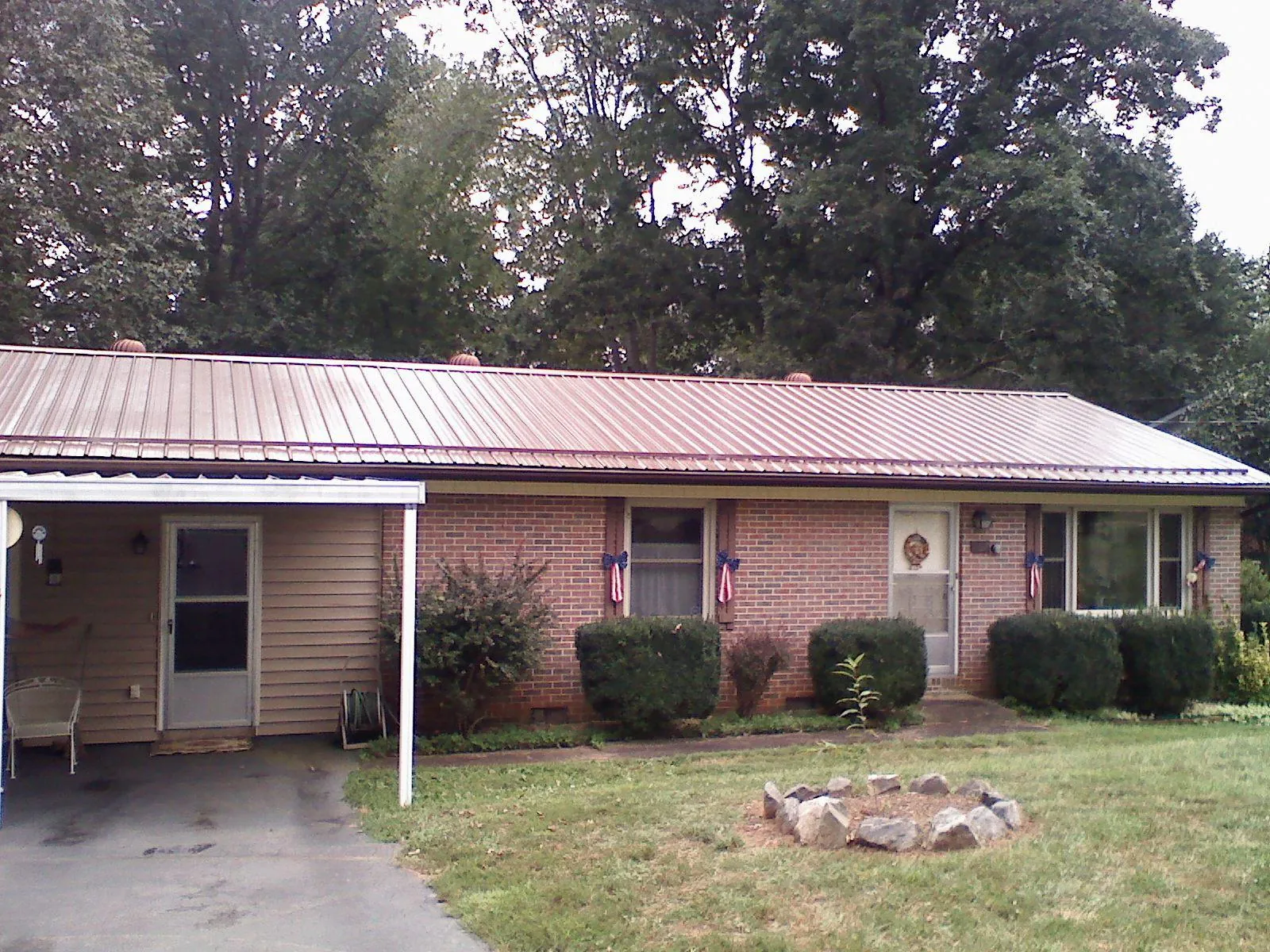 Bronze metal roof and carport on a brick ranch home — Roof Repair work by our crew in Pico Rivera